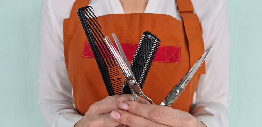 Woman hairdresser holding combs and scissors for hair cutting closeup